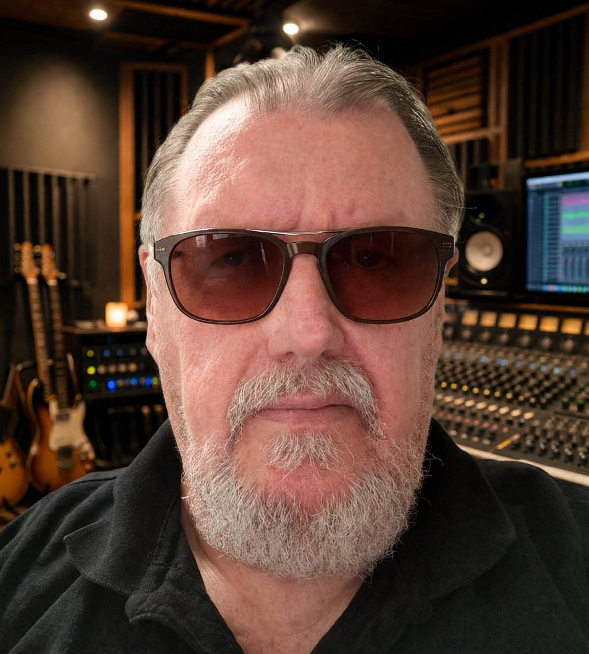 Jo Newfarmer in the recording studio, surrounded by guitars and a mixing console